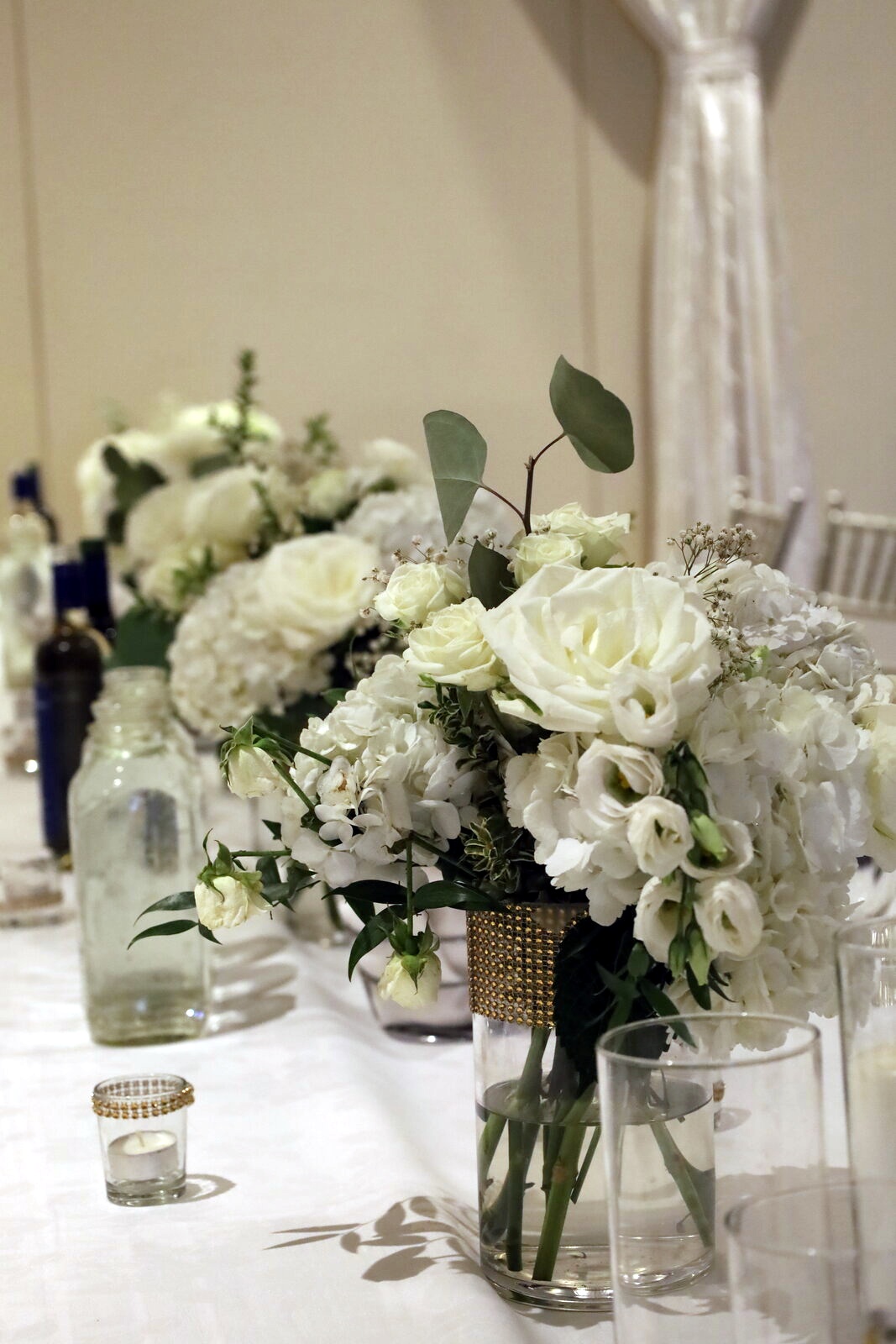 Head table centerpiece row with white roses and hydrangeas, arranged by Floral Gatherings for Ivana's wedding