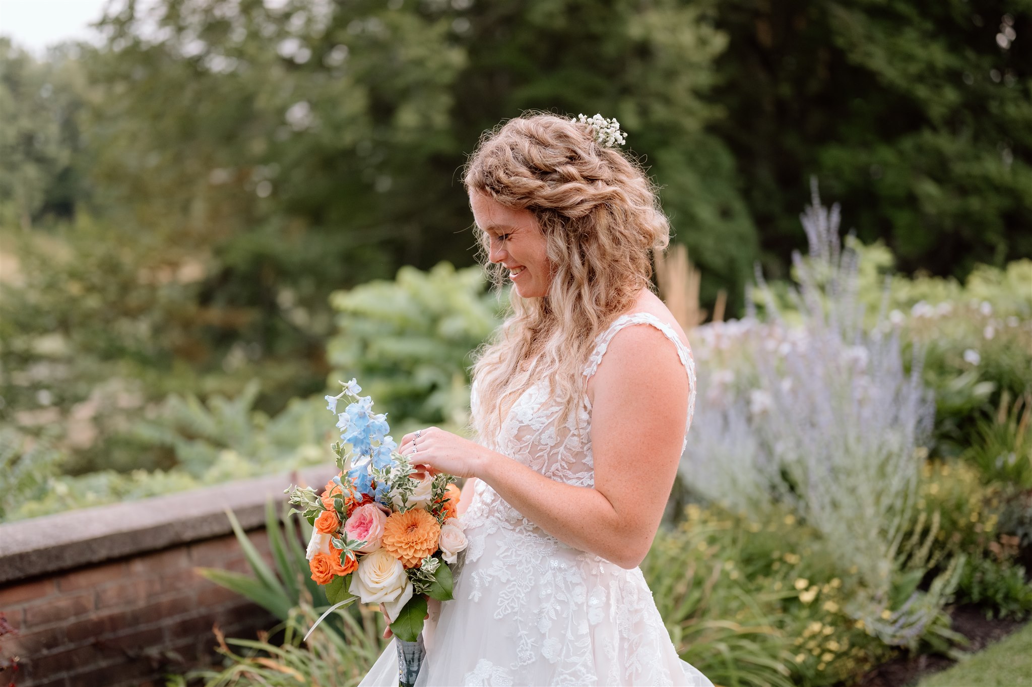 Jessie, bride holding her bouquet in a garden, whose wedding flowers were arranged by Floral Gatherings